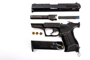 Dismantled firearm showing parts that can be safely cleaned using ASONIC ultrasonic cleaning technology.